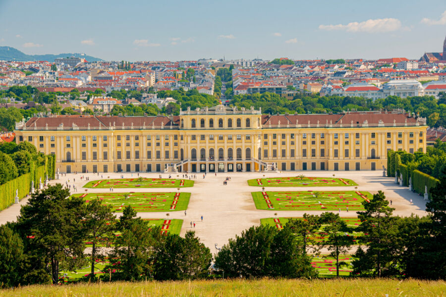 Panoramic aerial view of Schönbrunn Palace surrounded by Vienna's cityscape, highlighting its architectural beauty