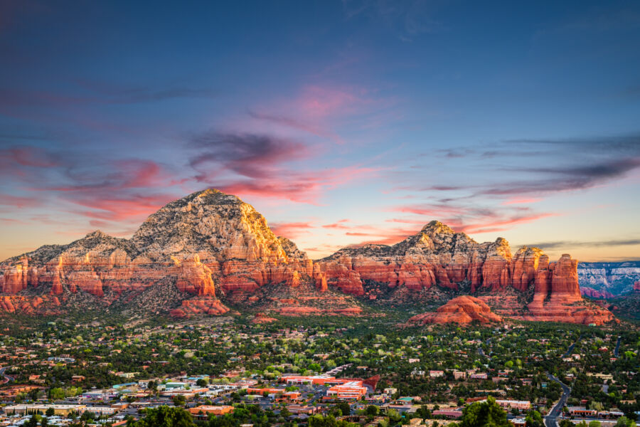 Beautiful sunset over Sedona, Arizona, highlighting the city skyline against a backdrop of striking red rock formations