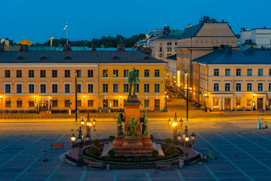 Night view of Senate Square in front of Helsinki Cathedral, illuminated against the dark sky, showcasing architectural beauty 