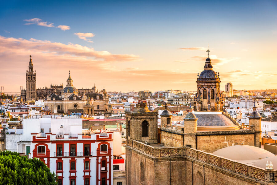 Beautiful Seville skyline at sunset, featuring iconic buildings and a colorful sky that captures the essence of the city