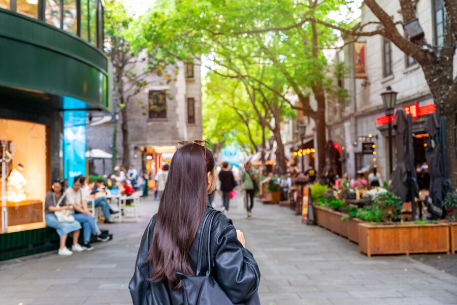 Young female tourist walking at Xintiandi shopping street landmark and popular attractions in Shanghai, China