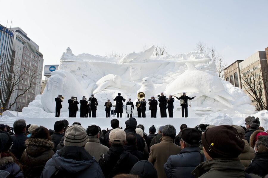 Snow festival: large marine-animal snow sculpture, live brass band performance in an urban winter setting.