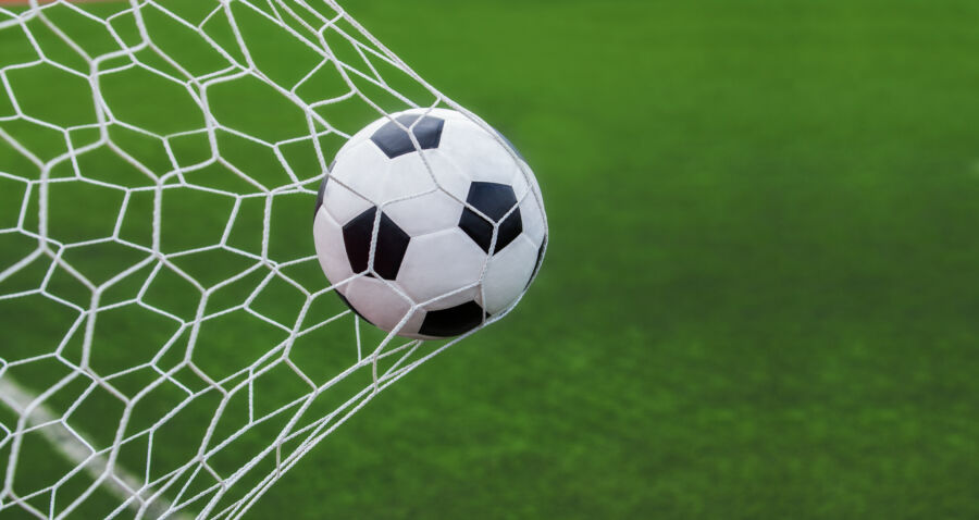 Soccer ball nestled in a goal, set against a vibrant green background