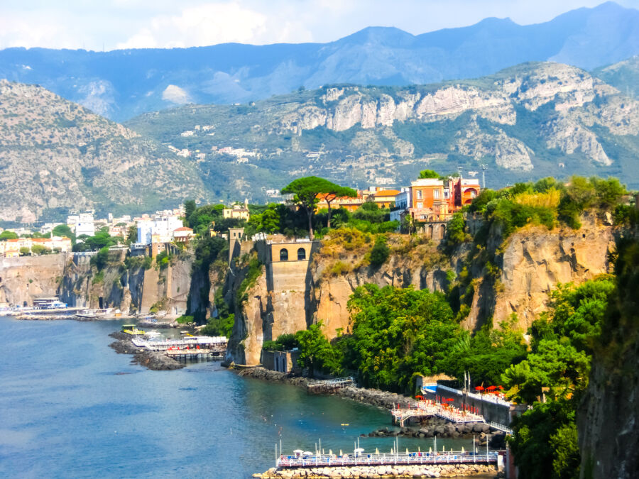 Scenic view of the Sorrento coast in Italy, showcasing cliffs, blue waters, and lush greenery under a clear sky