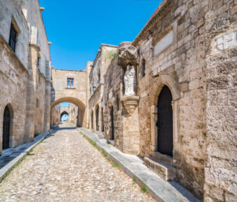 Scenic Street of the Knights of Rhodes lined with historic castle architecture and a prominent wall in Rhodes, Greece