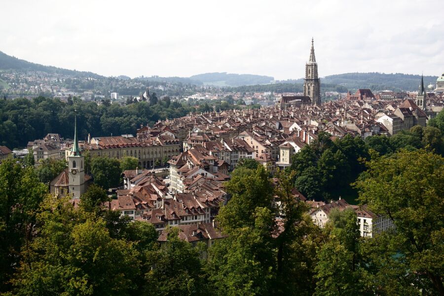 Aerial view of Bern, Switzerland with historic rooftops and greenery.