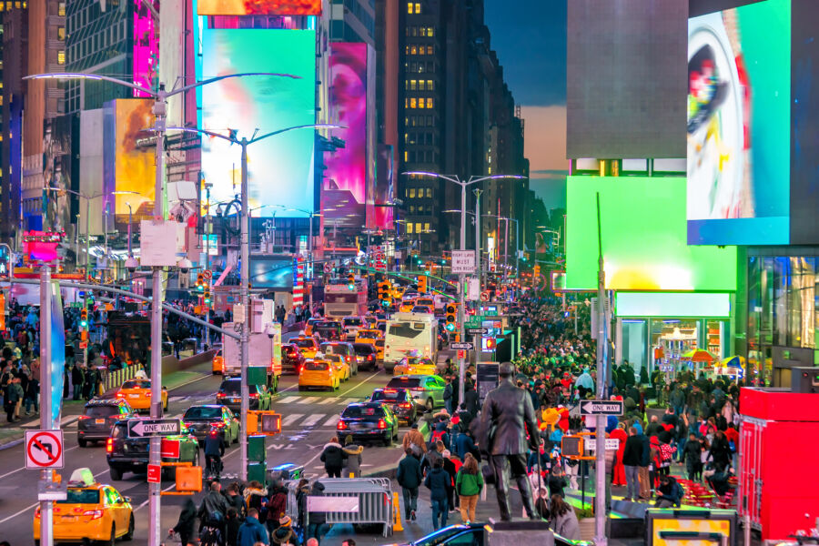 Bustling Times Square in Manhattan, New York City, featuring bright lights, large billboards, and crowds of people