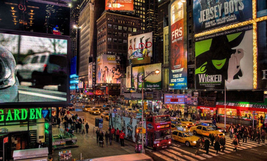 Nighttime scene of Times Square, highlighting the bright billboards on Broadway in New York City