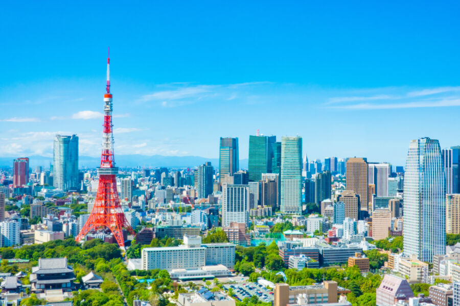 The iconic Tokyo Tower stands tall in the cityscape, surrounded by a skyline that reflects modern architectural design.