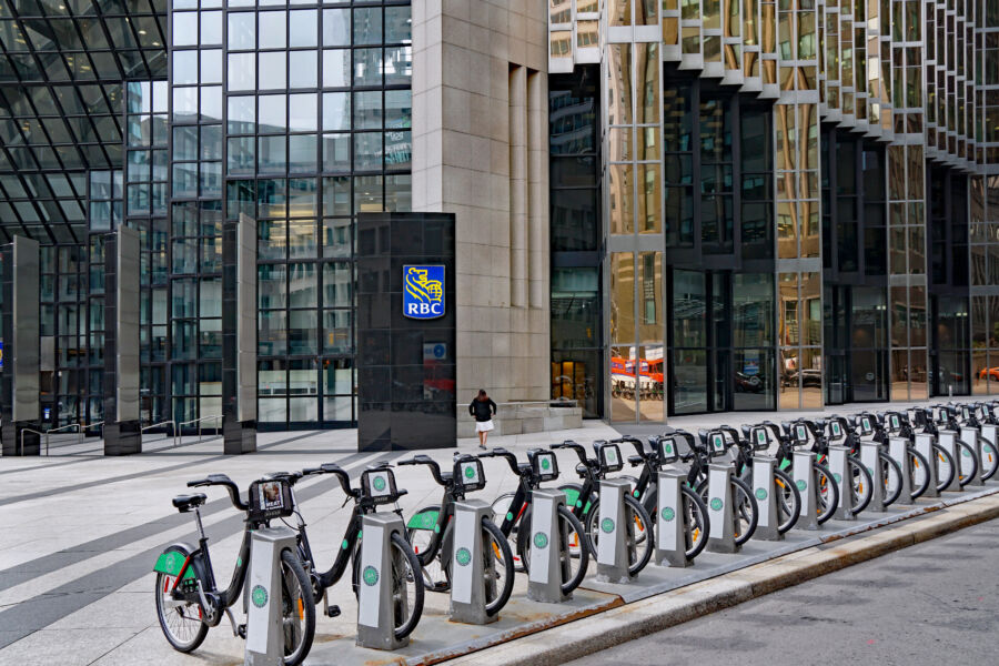 Row of RBC bike share bicycles parked in front of a contemporary office building in Toronto's financial district