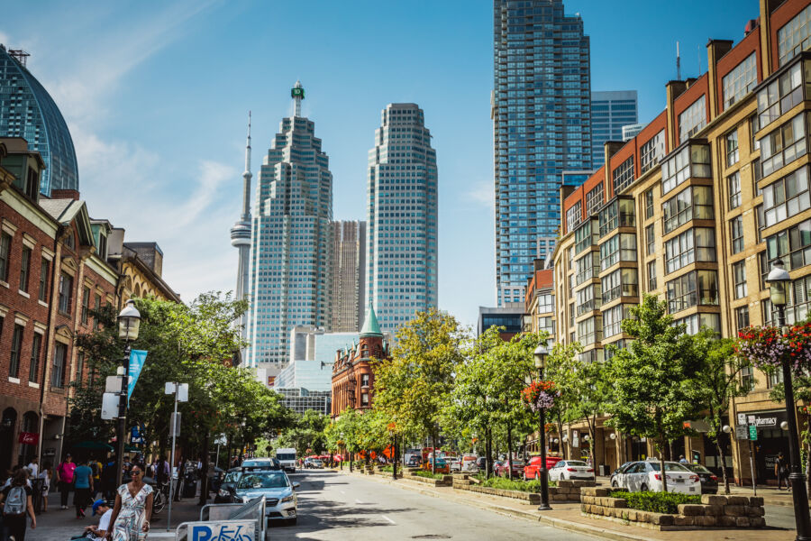 Toronto's busiest intersection in rush hour, featuring heavy traffic and the financial district towering in the background