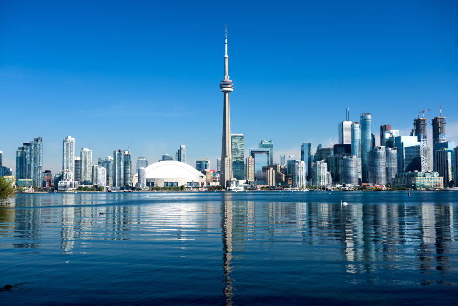 The Toronto skyline showcases the CN Tower and modern buildings, set against a vibrant urban backdrop.