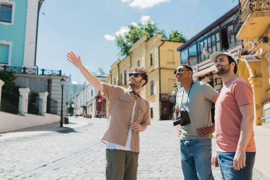 Tour guide wearing sunglasses directs a diverse group of tourists