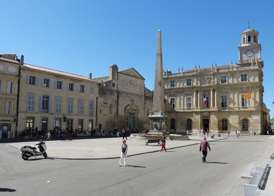 Vibrant European town square with historic architecture, lively atmosphere, fountain, and municipal building.