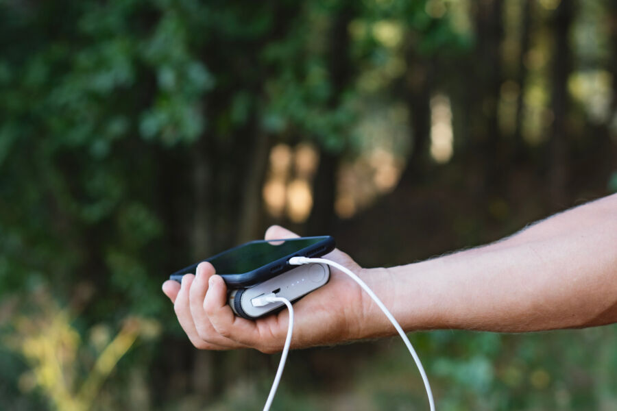 Tourist displays a portable charger and smartphone, emphasizing the importance of staying powered while on the go