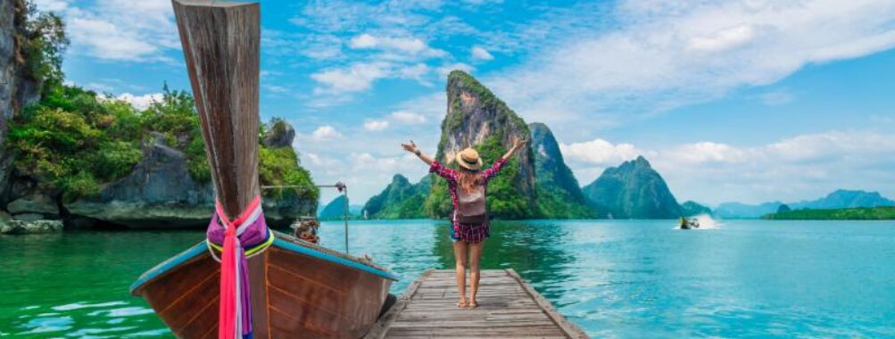 Lady tourist enjoying the scenic views of Phang-Nga Bay in Phuket, surrounded by stunning limestone cliffs and clear waters