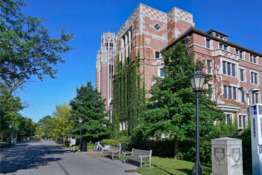 Picturesque footpath on the University of Chicago campus, lined with trees and leading to iconic architectural structures