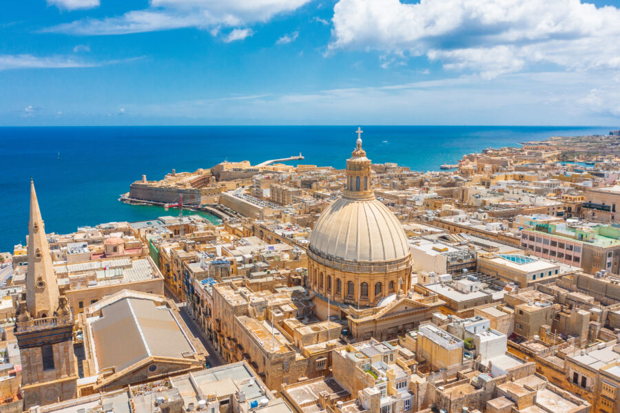 Aerial perspective of Valletta, Malta, featuring the Lady of Mount Carmel church alongside St. Paul's Cathedral in the cityscape