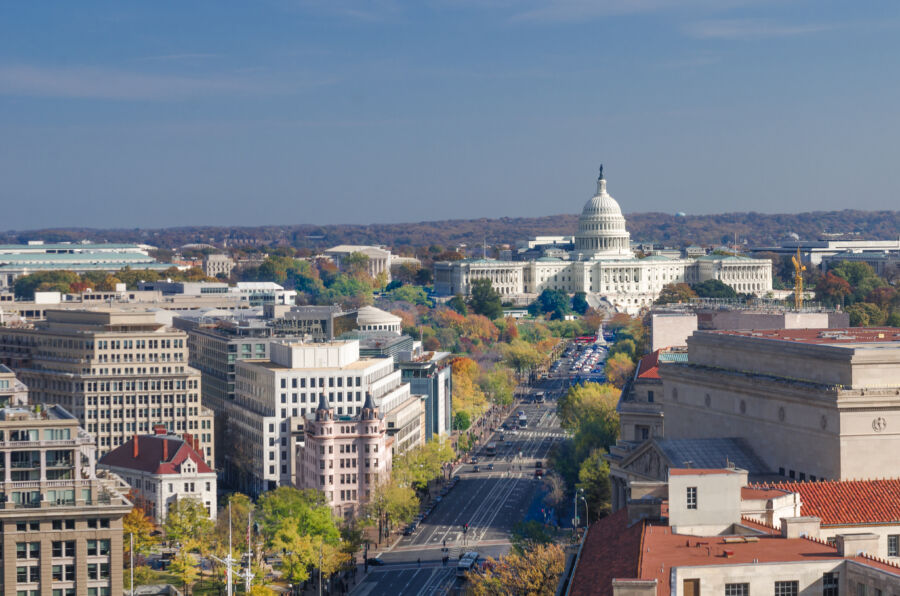 The skyline of Washington D.C. showcasing Capitol Hill alongside other prominent federal buildings under a bright sky