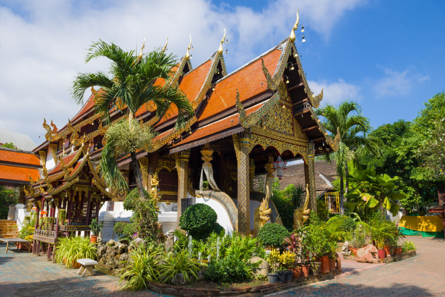 The Vihan at Wat Ket Karam temple in Chiang Mai, Thailand, illuminated by sunlight on a bright day.