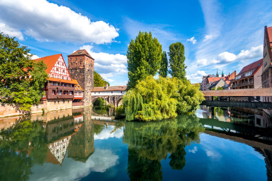 Scenic view of Henkersteg bridge and Weinstadel building in Nuremberg, showcasing historic architecture and picturesque surroundings