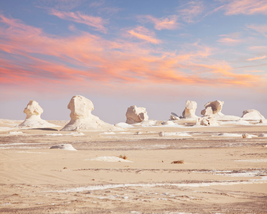 Picturesque sunset view of Egypt's white desert, highlighting the unique terrain under a colorful sky